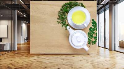 Moringa Tea in white cup and fresh green leaf with teapot on wooden background, top view. Moringa oleifera tropical herb healthy lifestyle concept. Wall mural