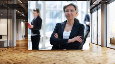 Mature businesswoman standing in office Wall mural