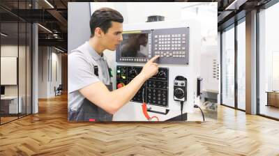 Worker pressing buttons on CNC machine Wall mural