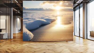 Golden sunlight illuminating a snowy beach, winter ocean waves gently rolling in, a beautiful blend of warmth and chill in a picturesque landscape Wall mural