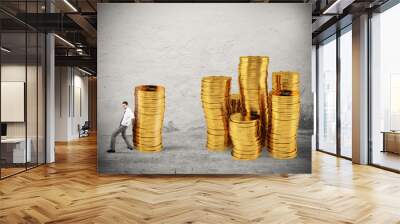 Businessman moves a pile of coins to a group of money. concept of difficulty to saving money Wall mural