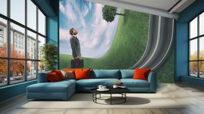 Businessman observes the road uphill in front of him. Achievement business goal and difficult career concept Wall mural