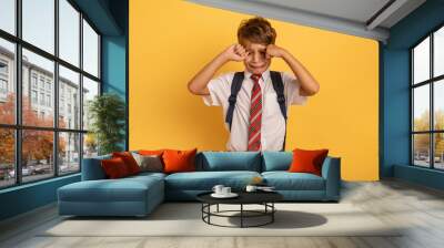 Child cries because does not want to go to school. Yellow background Wall mural