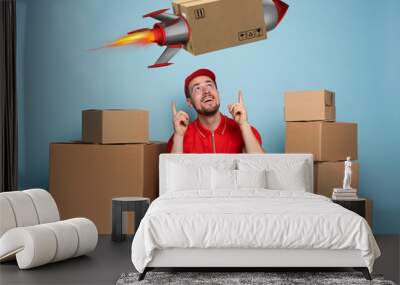 Courier is happy because boxes are delivery fast like a rocket. Studio on cyan background Wall mural