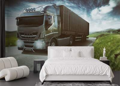 Grey truck moving fast on the road in a natural landscape with cloudy sky Wall mural