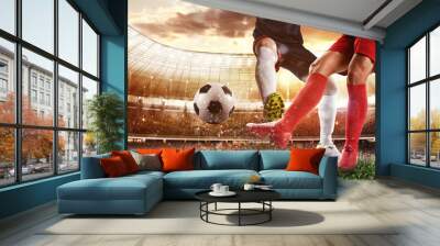 Soccer scene at the stadium with player in a red uniform kicking the ball and opponent in tackle to defend Wall mural