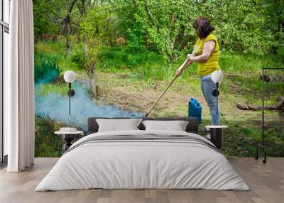 woman burns the grass in the village in the garden Wall mural