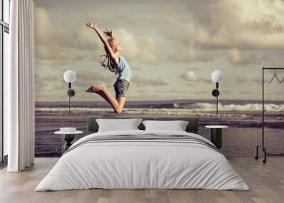 teen girl  jumping on the beach at blue sea shore in summer vaca Wall mural