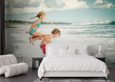 Two happy children  playing on the beach Wall mural