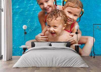 two little girls and little boy playing in the pool Wall mural