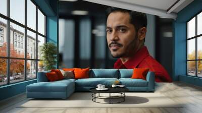 twenties hispanic man in red attire on office background model portrait looking confident for ad concept space for text Wall mural