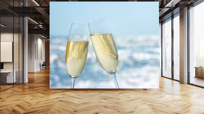 two glasses of champagne on the sea beach Wall mural