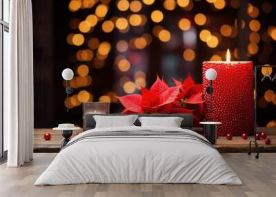 red poinsettia on wooden table with softly glowing holiday candles Wall mural