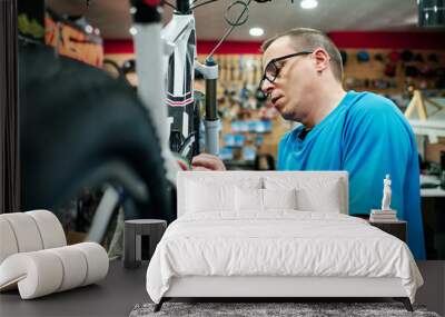 a man repairs a bike in his small business workshop Wall mural