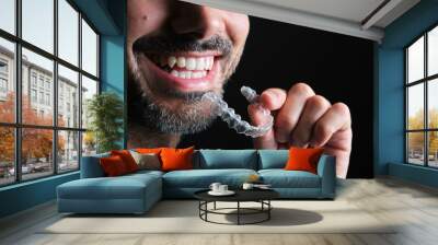 bearded guy putting on transparent dental retainer Wall mural