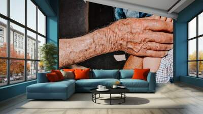 hand of an elderly man holding and stroking a baby's hand, Wall mural