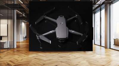 New dark grey drone quadcopter with digital camera and sensors flying isolated on black background Wall mural