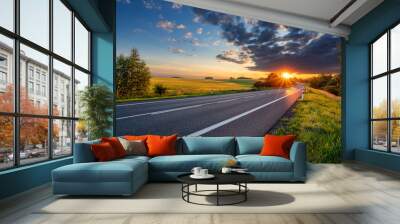 Empty asphalt road in rural landscape in the rays of the sunset with dark storm cloud Wall mural