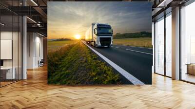 White truck arriving on the asphalt road in rural landscape at sunset Wall mural