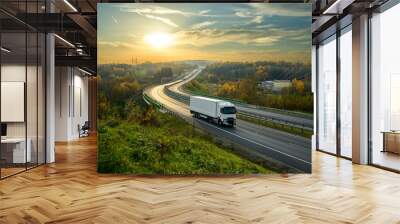 White truck driving on the highway winding through forested landscape in autumn colors at sunset Wall mural