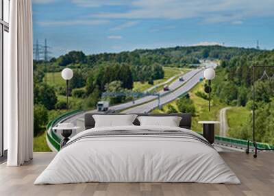 white trucks drive along an asphalt highway with electronic toll gate in a wooded landscape. view fr Wall mural