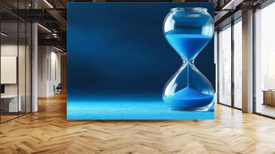 Hourglass measuring passing time on blue background Wall mural