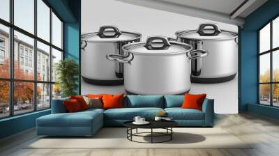 Three stainless steel cooking pots with lids on a white background Wall mural