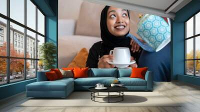 Black Muslim woman drinking hot beverage Wall mural