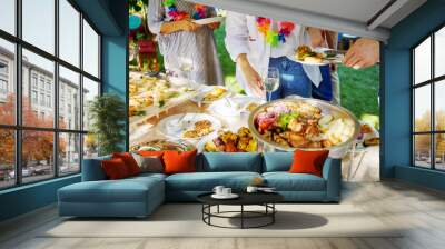 Hands take food at a party Wall mural