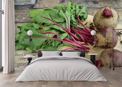 Bunch of fresh beetroots with leaves on wooden board Wall mural