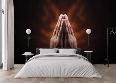 Praying hands with faith in religion and belief in God on dark background. Power of hope or love and devotion. Wall mural