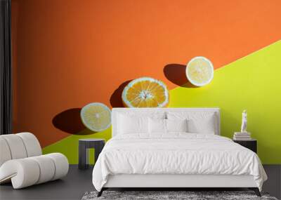 two slices of lemon and one slice of orange on an orange and yellow background
 Wall mural