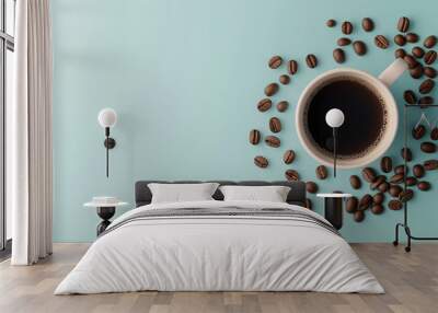 Cup of black coffee surrounded by scattered coffee beans on a light blue background. Flat lay composition with copy space. Wall mural