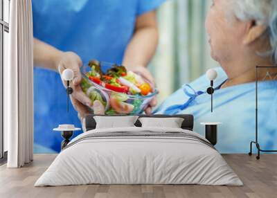 Asian senior or elderly old lady woman patient eating breakfast healthy food with hope and happy while sitting and hungry on bed in hospital. Wall mural