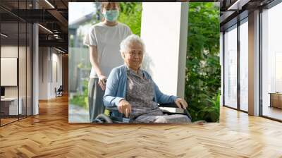 Caregiver help and care Asian senior woman patient sitting on wheelchair to ramp in nursing hospital, healthy strong medical concept. Wall mural