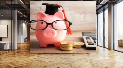 Pigging bank wearing eyeglass with coins and calculator; saving bank education concept. Wall mural