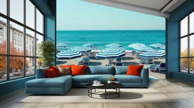 blue and white striped beach umbrellas along the shore with waves . Wall mural