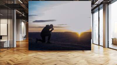 A man on his knees. Prayer of repentance for sins. Worship of God. Wall mural