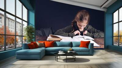 The girl reads the Bible book. Books on the table. Learning prayer. pray Wall mural