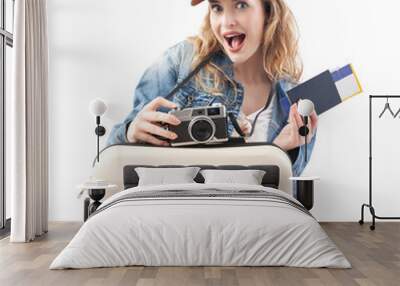 Excited young woman tourist traveler with camera taking a photo with trolley suitcase and flight ticket, isolated on white background. Concept of summer holiday or travel influencer content creator Wall mural