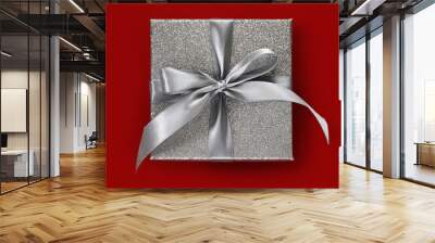 gift silver glittering box with ribbon bow, isolated on red background, top view, useful for merry christmas, mother day or valentine day shopping concept Wall mural