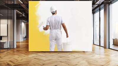 Rear view of painter man painting the wall, with paint roller and bucket, isolated on big empty copy space template Wall mural