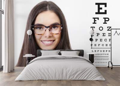 smile female face with spectacles on eyesight test chart background, eye examination ophthalmology concept Wall mural