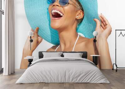 Smiling girl wearing a turquoise sun hat, blue sunglasses and bikini, African latin American woman isolated on white background. Concept of a seaside holiday or shopping for a summer beach holiday Wall mural