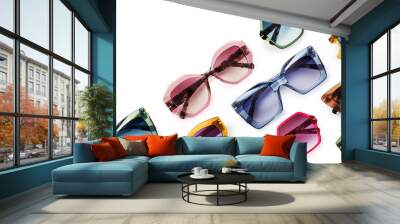 Sunglasses composition in many bright colors in transparent plastic. Top view with shadow. Trendy glasses isolated on white background. Glasses with polarized lenses. Fashionable eyewear for women. Wall mural