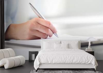 Woman's hands writing on sheet of paper in a clipboard and a pen Wall mural