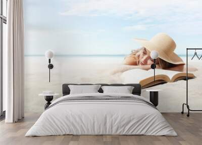 woman lying on sand beach with book, resting wear sun straw hat for sun protection her skin face. Concept of summer beach holiday and vacation travel. Sea and blue sky panoramic Background copy space Wall mural