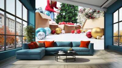 Woman prepare christmas tree with cardboard boxes full of christmas balls and decorations, preparation concept background with copy space  Wall mural