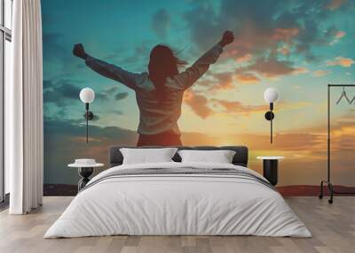 Confident successful woman celebrating achievement with arms raised in a motivational and inspirational setting, symbolizing empowerment and personal growth. Wall mural