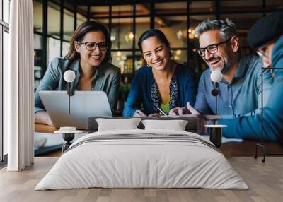 Diverse and happy business team having a casual meeting to analyze financial data on laptop and tablet Wall mural